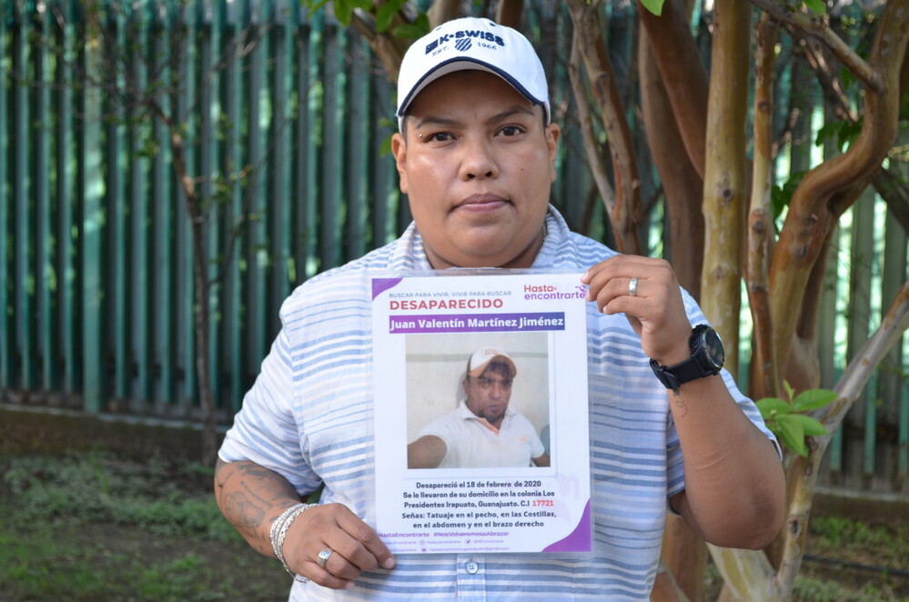 Karla is holding an image of her brother, who was forcibly disappeared.