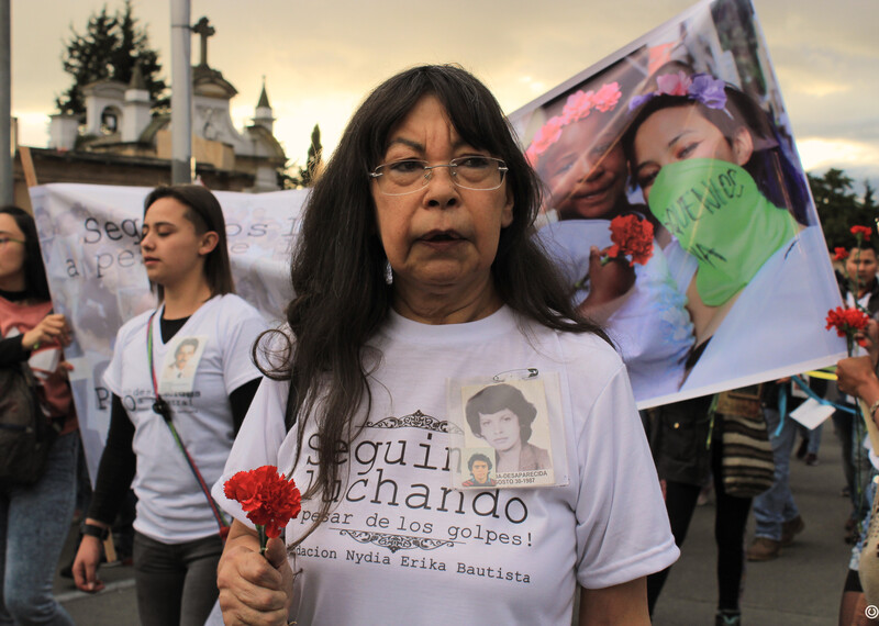 Yanette Bautista stands among a group of women as the sun sets in Colombia